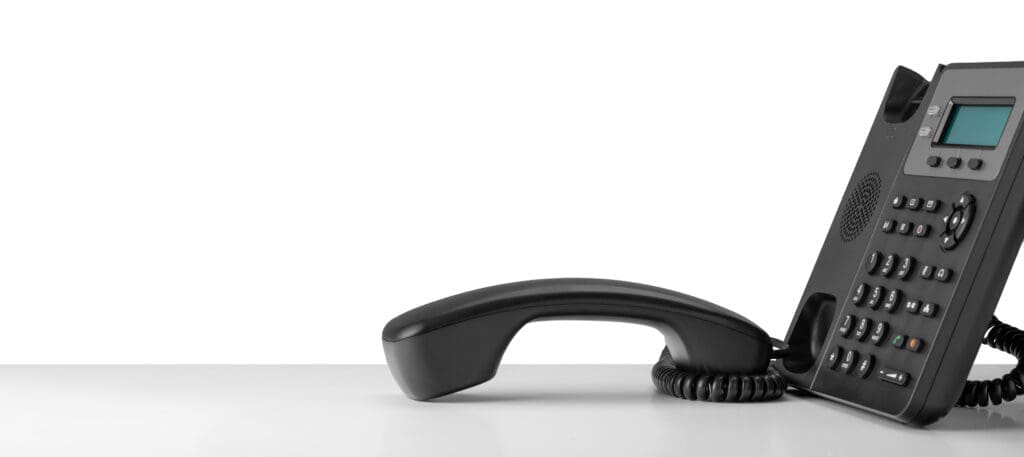 Close up telephone devices at office desk for customer service support with B2B service technology concept. telephone with VOIP